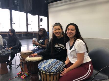 Dani's classmates pose for a photo in front of their standing drums at the dance studio