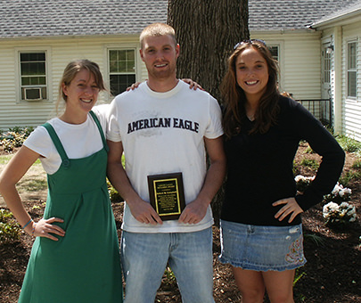 Thee Human Development students smile with an award plaque.