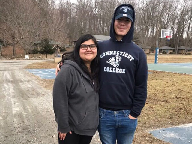 Two students outside smiling on a basketball court