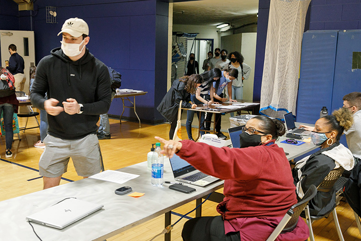 A student is pointed towards the check in for the COVID-19 vaccine. 