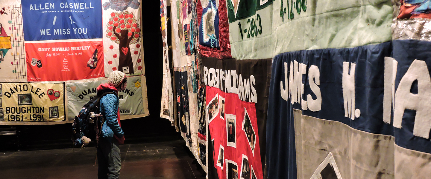 A student looks closely at the AIDS Memorial Quilt panels on display in Conn