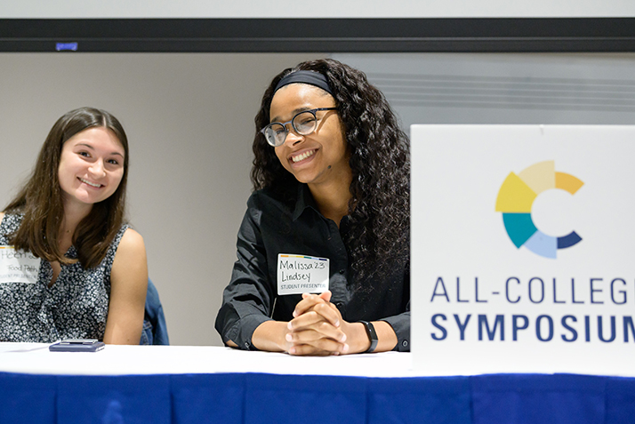 Two students smile as they wait to present