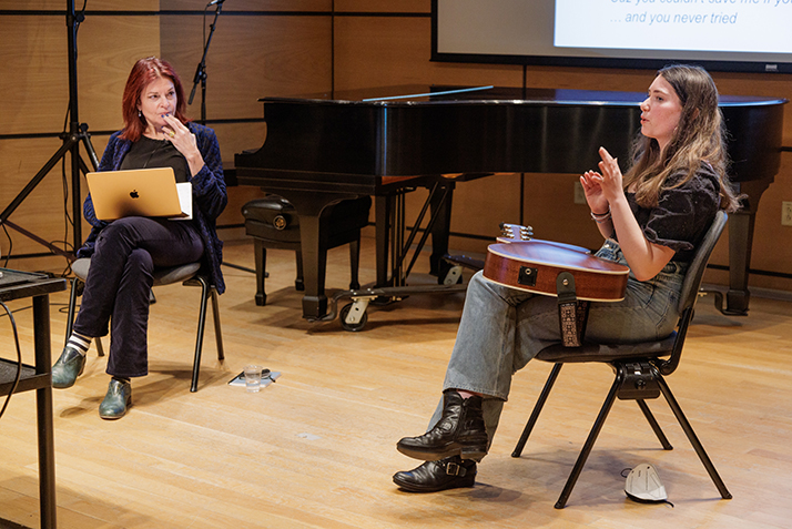 Cash listens intently as a student discusses her song writing work.