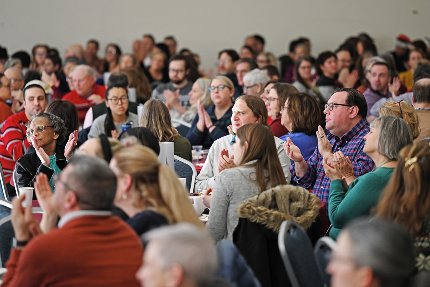 Staff applaud at the year-end holiday party.