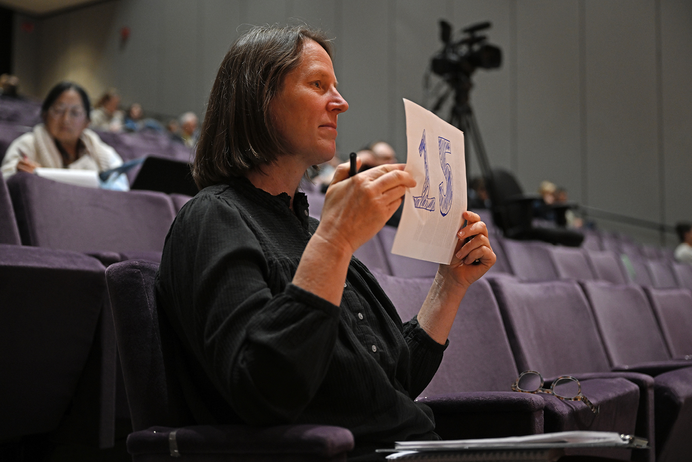 Maggie Redfern, Associate Director of the Connecticut College Arboretum, signals a speaker about the time remaining in a presentation.