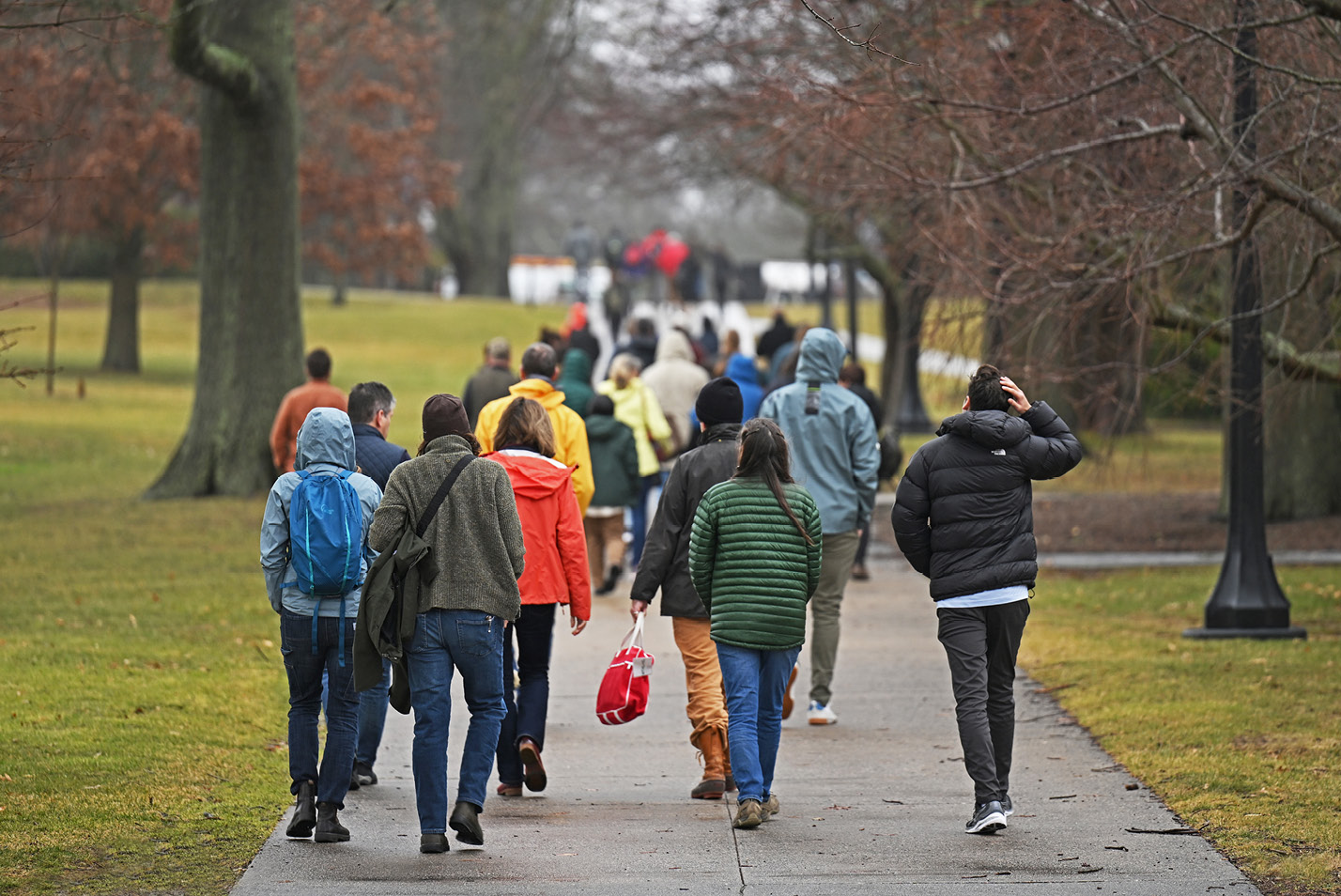 People walking away from camera on sidewalk by Tempel Green