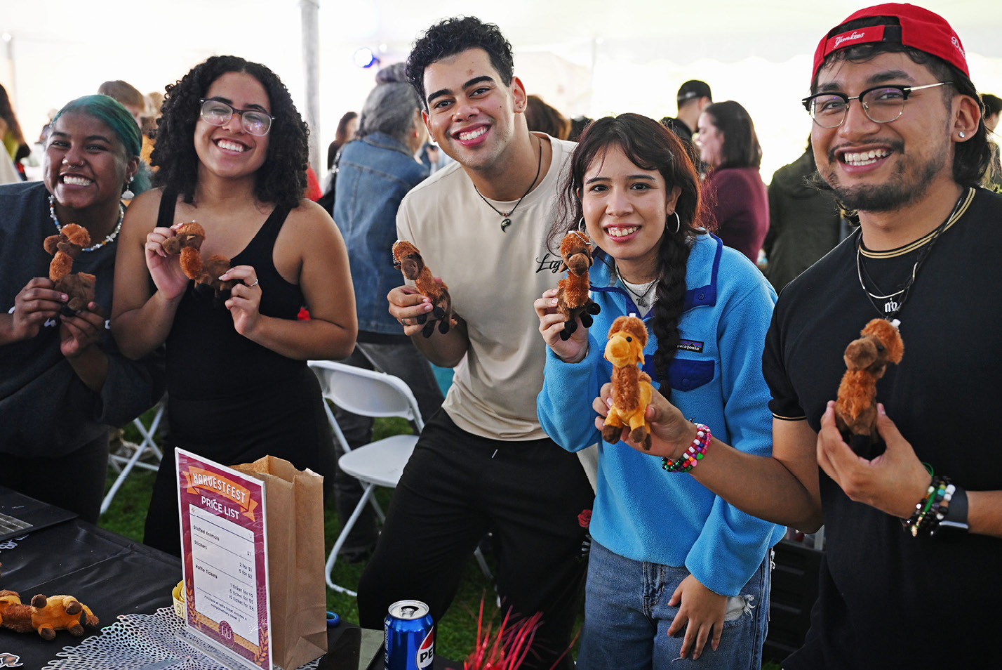 Students hold toy camels at Harvestfest.