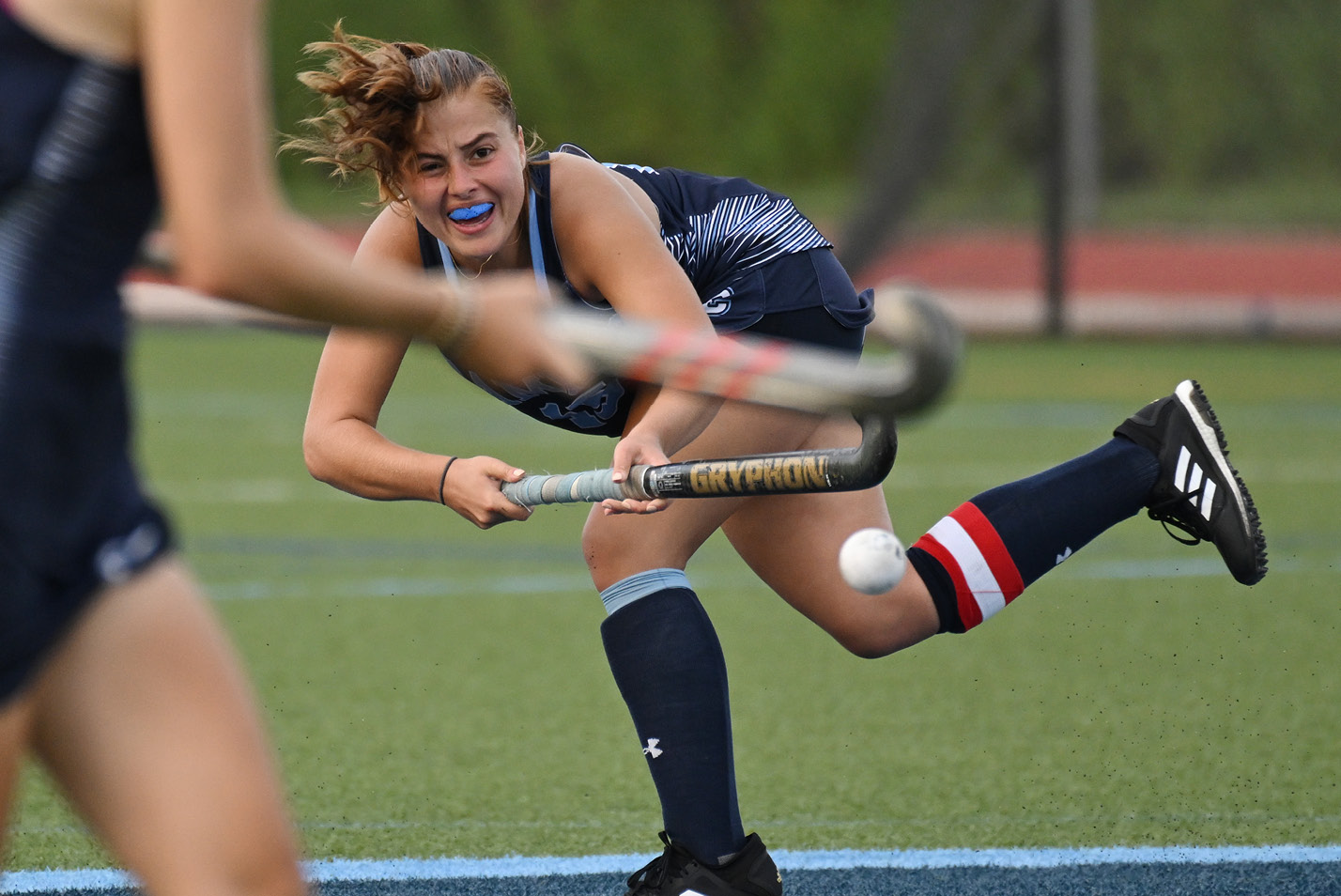 Women's field hockey player takes a shot