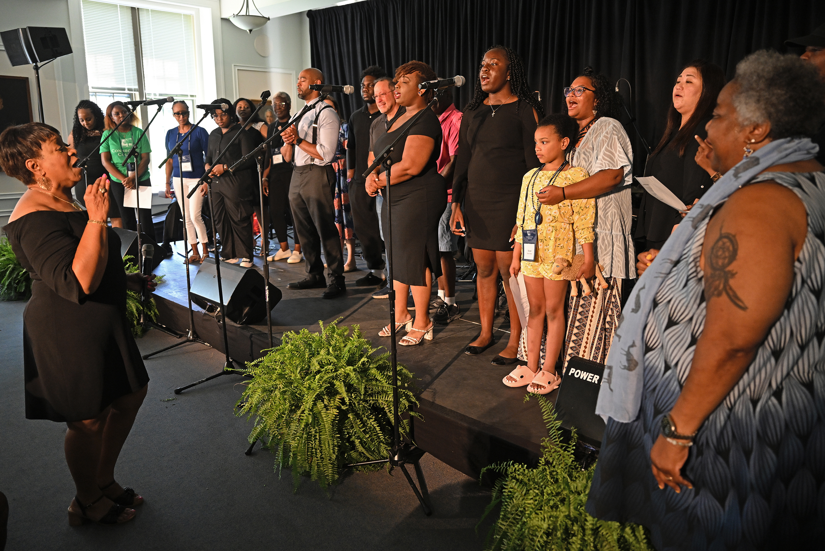 A large gospel choir performs on stage