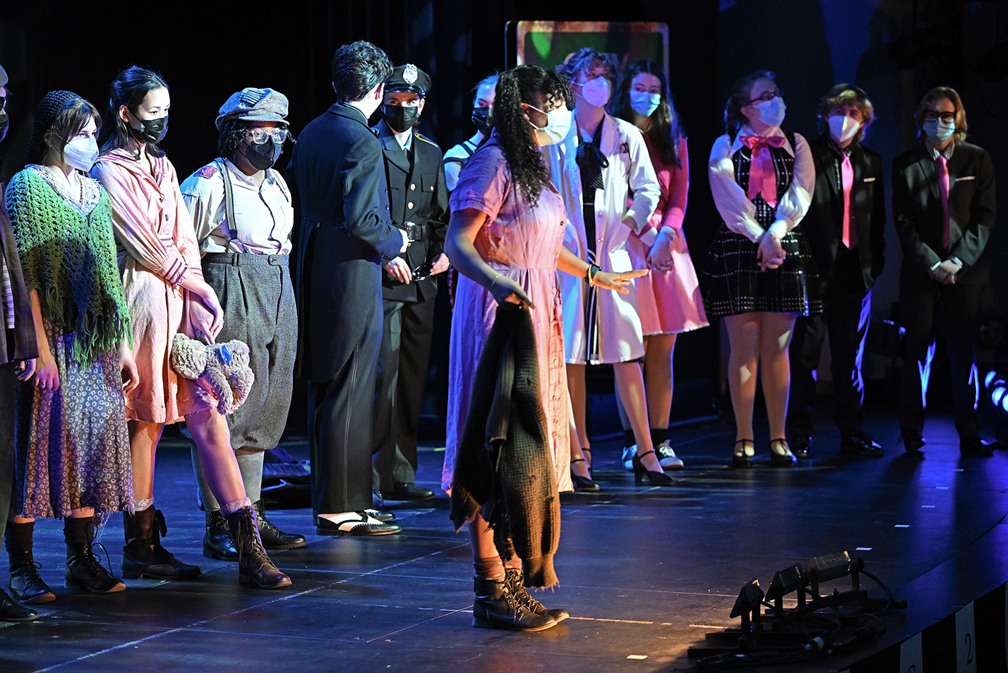 actors stand on stage in costumes