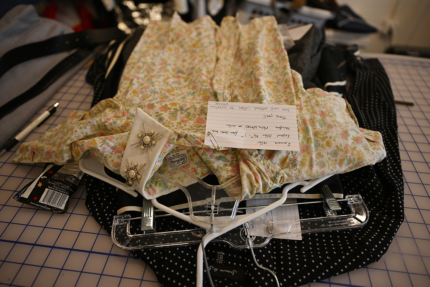 stack of costumes with notes pinned to them