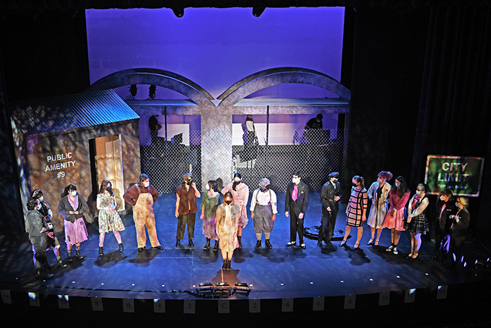 The cast of Urinetown performs during a tech rehearsal.