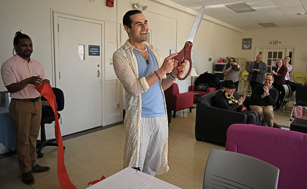 Person with giant scissors cuts ribbon