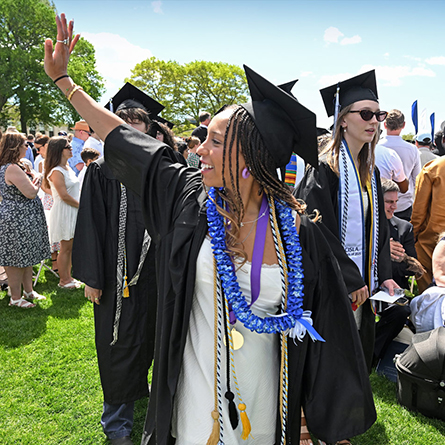 A graduate waves to the crowd.