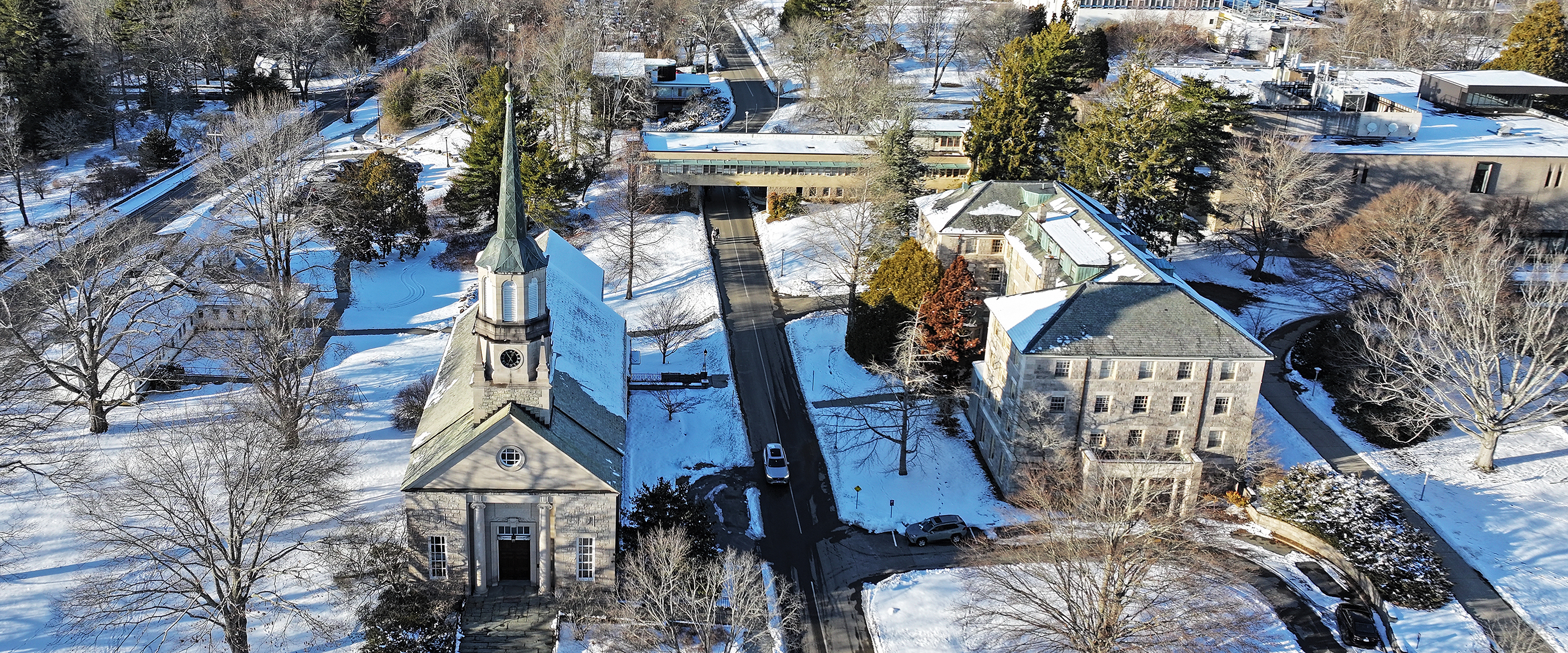 Aerial view of college chapel blanketed in snow.