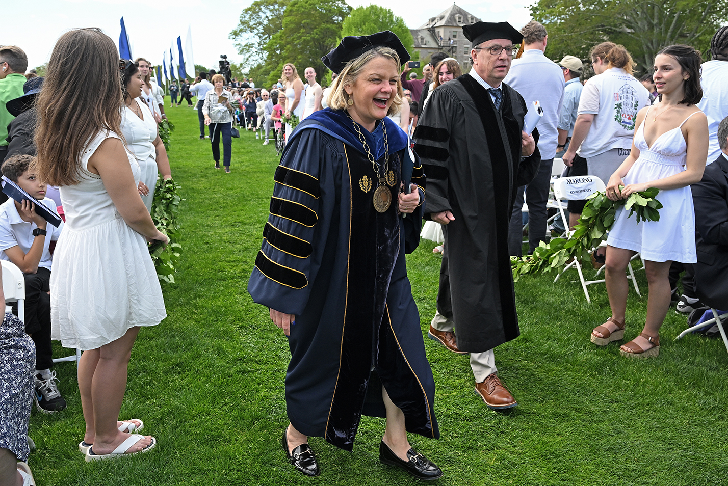 The college president and guest speaker smile as they process toward to stage during commencement exercises.