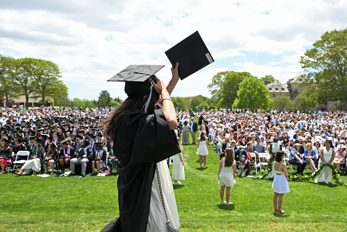 A graduate holds her diploma aloft as she crosses the stage during commencement exercises.