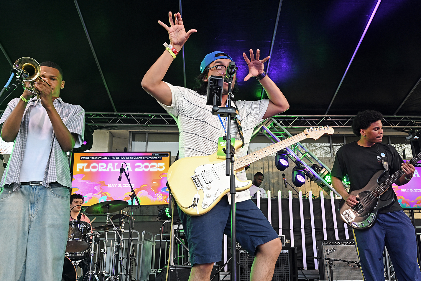 A student band performs onstage during an outdoor music festival.